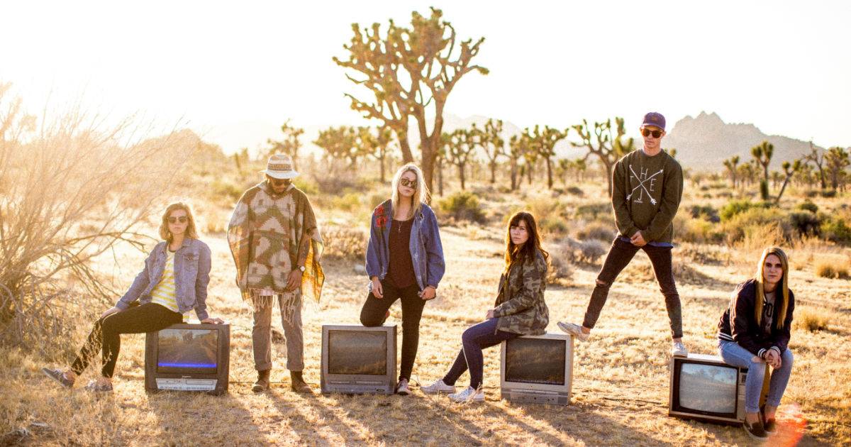 Group of talent sitting on TVs in the desert for social engagement.