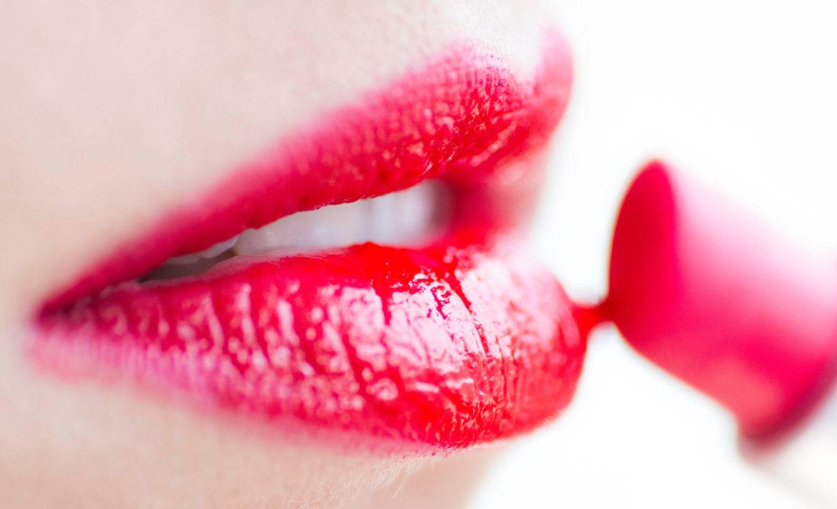 Close-up of woman's lips as lipstick is applied.
