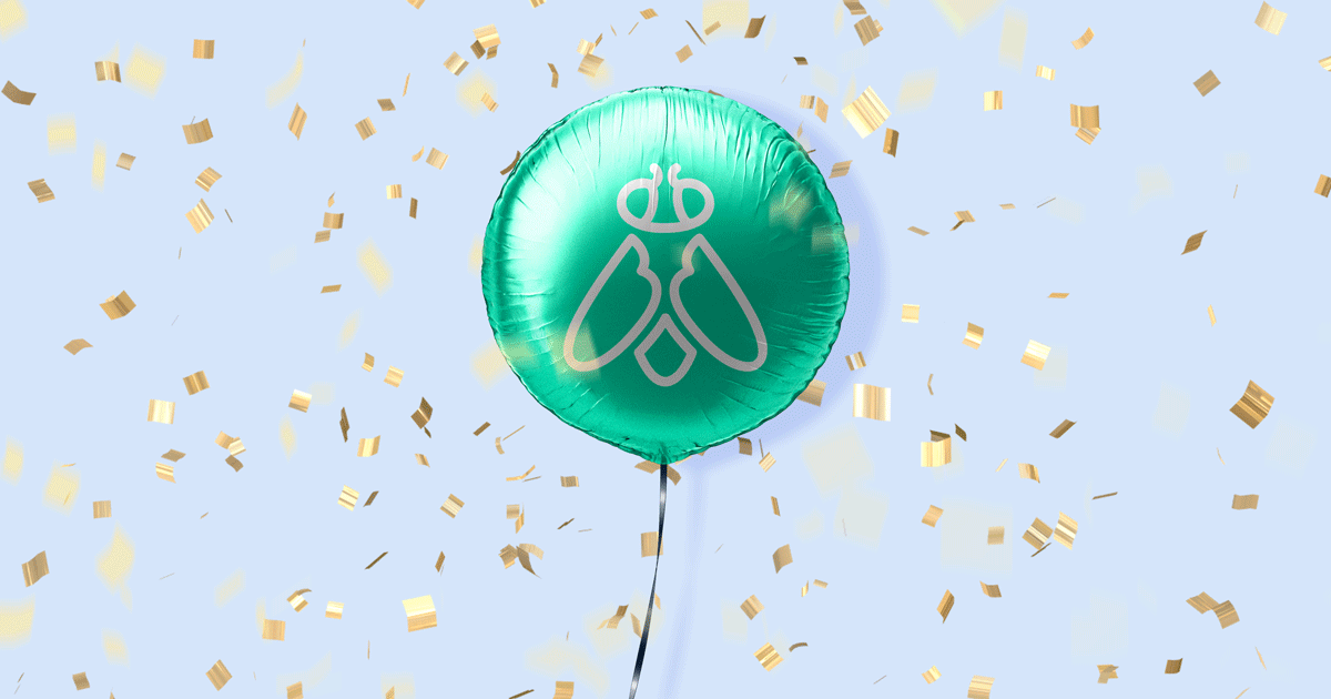 A green mylar balloon with the with a Greenfly logo floats amid confetti.