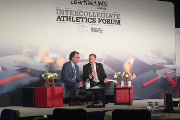 pac 12 commissioner larry scott on stage with sports business journal