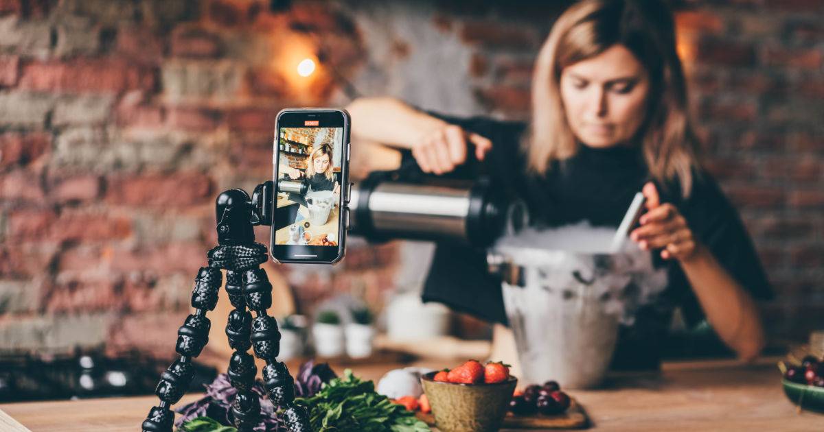 Advocacy Marketing in action: Female chef sets up camera shot in kitchen.