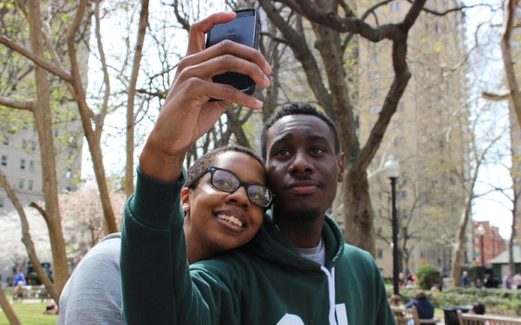 Male and female siblings taking self outside.