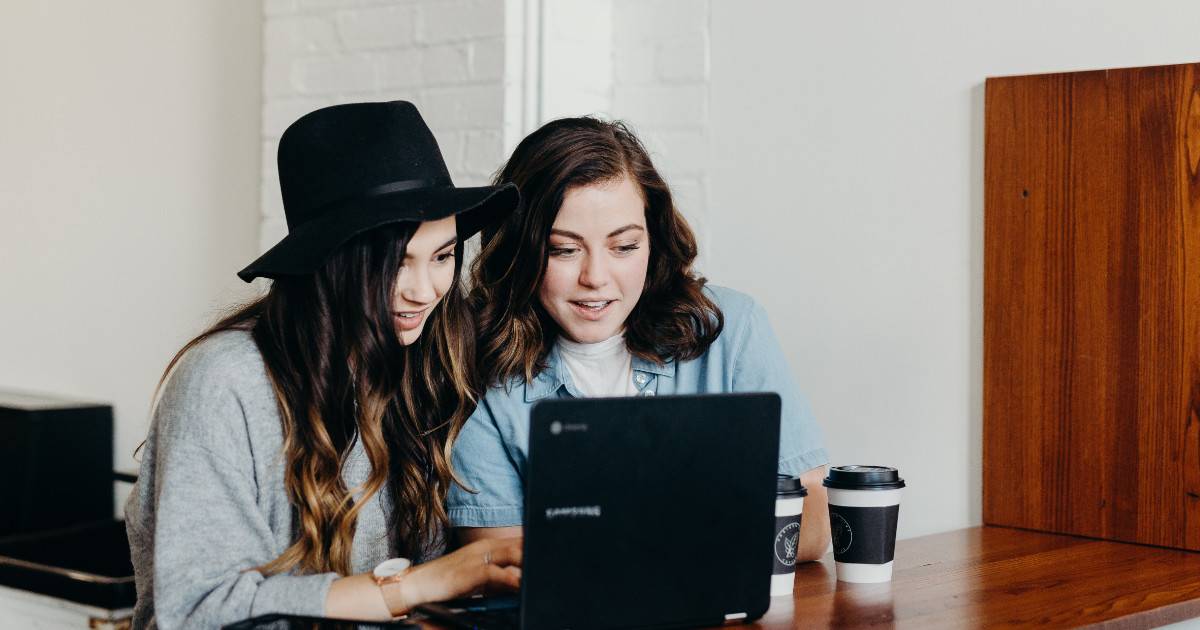 Brand advocates collaborating at a computer for advocacy marketing on social media.