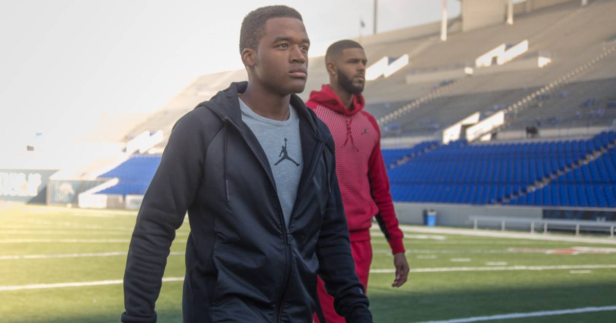 Athlete branding - two athletes in sweats walking across stadium field.