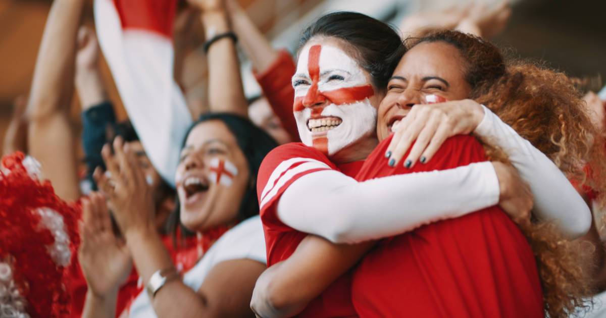 Two fans in stand celebrating; fan engagement to increase ticket sales.