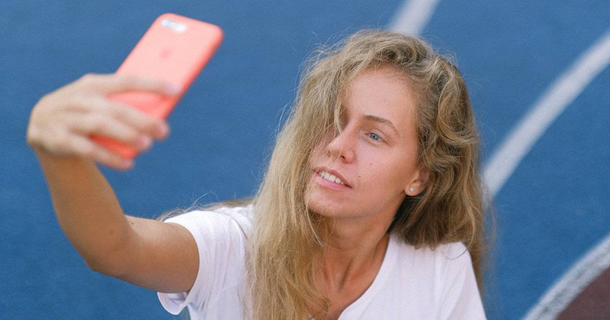 Female athlete taking a selfie on a track showing athletes as brand storytellers.