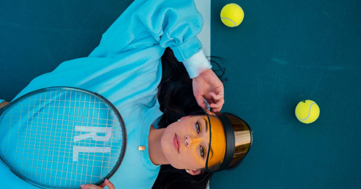 Sports marketing examples - woman in branded teal top on tennis court