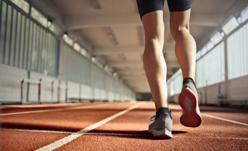 A male athlete running indoors