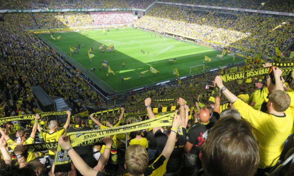 live events sports social media - fans in yellow cheering in stadium