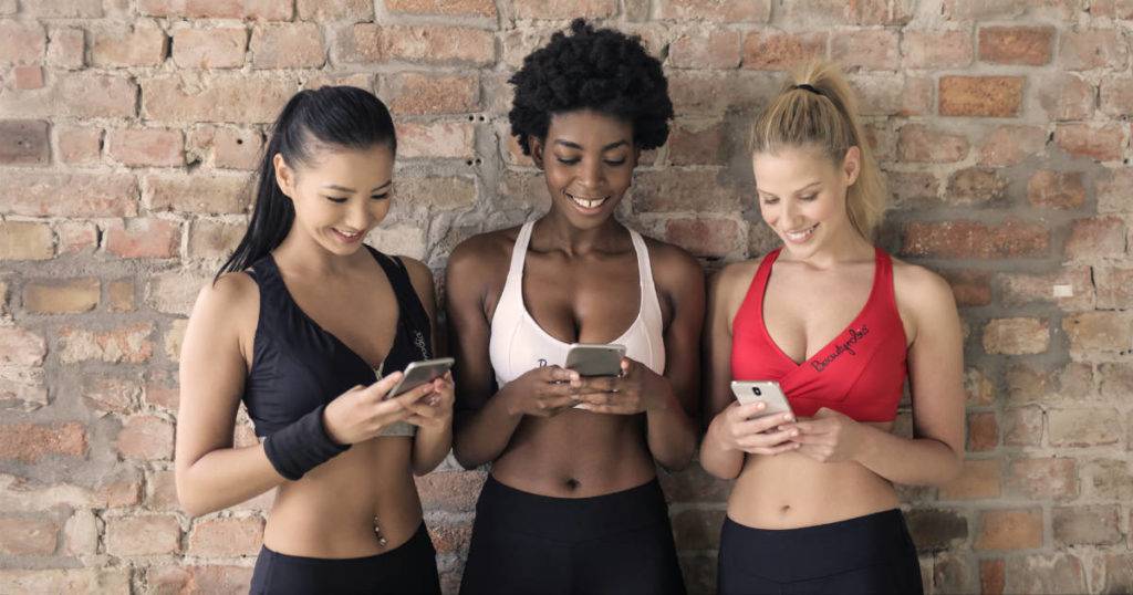 Social media platforms are diverse - three female athletes looking at mobile phones