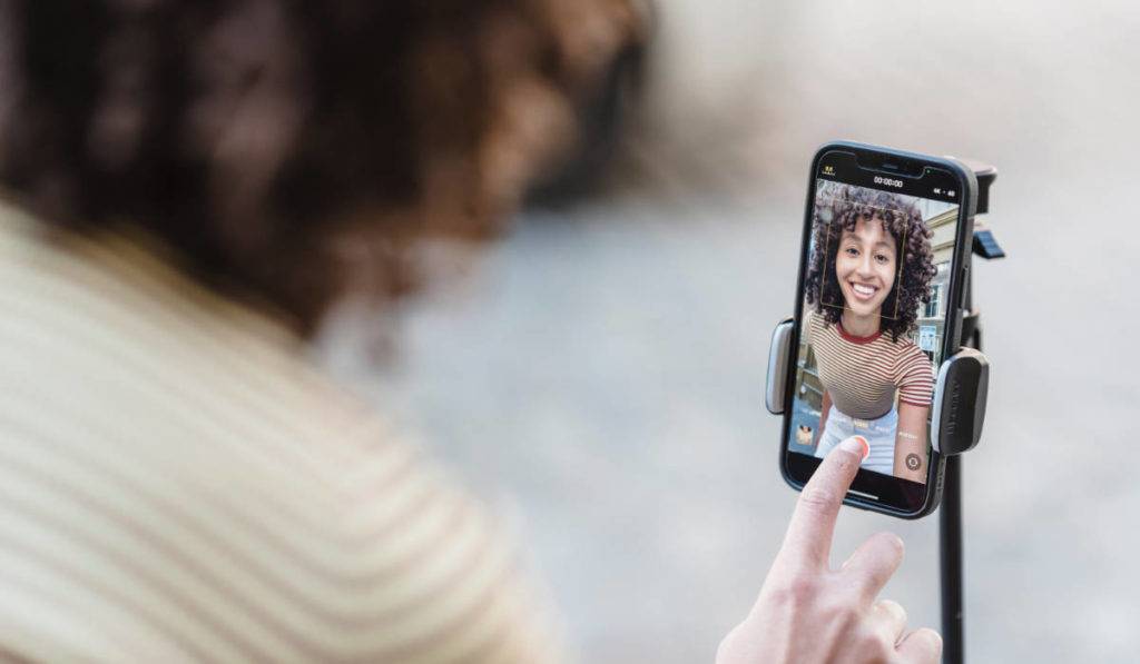 social-media-platforms woman taking selfie on phone tripod