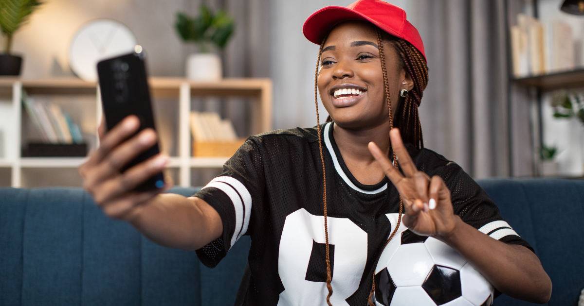 female soccer fan taking selfie at home for UGC campaign