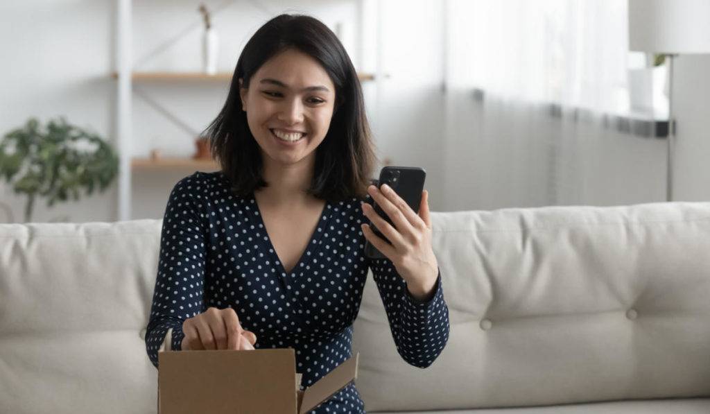 A woman taking video unboxing selfie for consumer generated content campaign