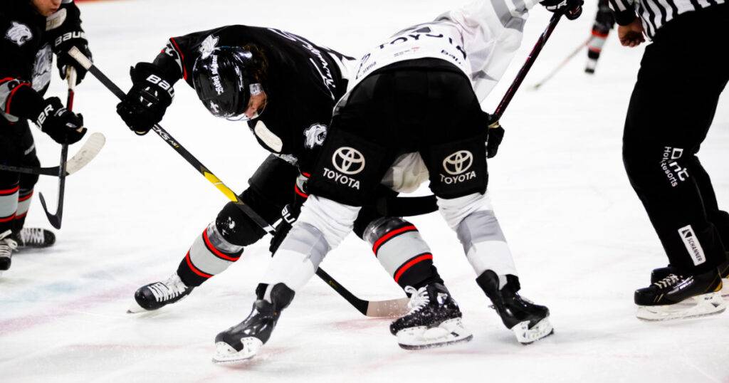 Two hockey players, with visible sponsor logos on uniforms and helmets, AI for sports sponsors.