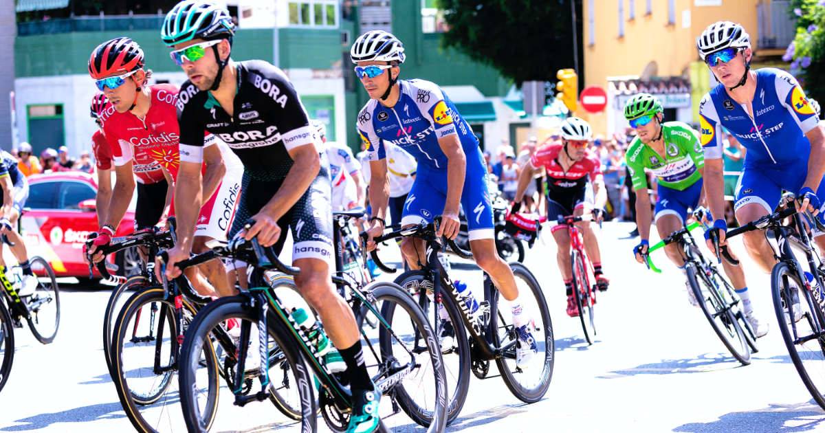 Group of competitive bicyclists with sponsor logos on jerseys - AI for sports sponsors.