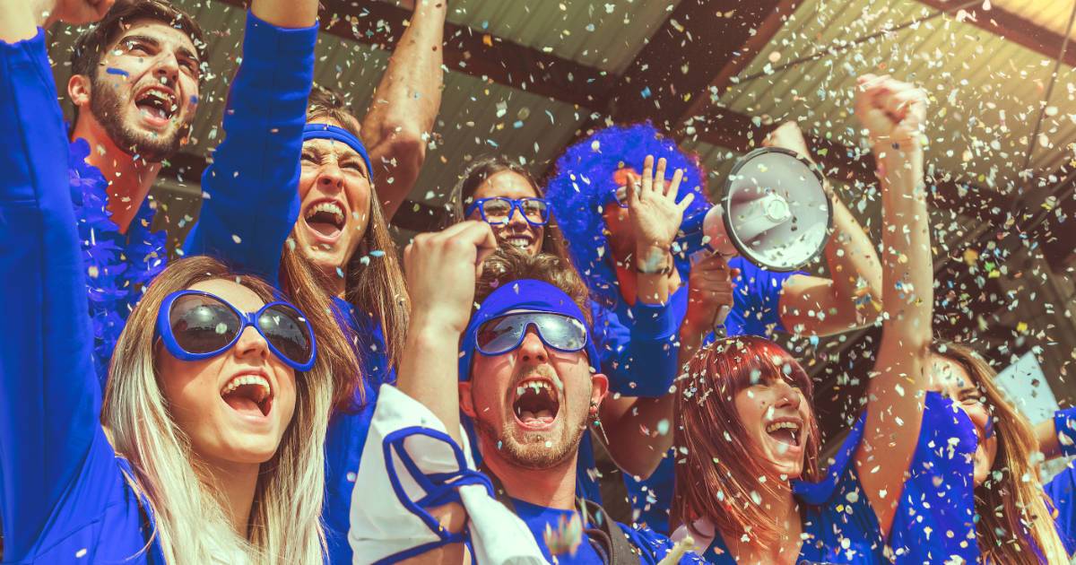 7 cheering fans dressed in blue color with confetti, showcasing global fan engagement in sports.