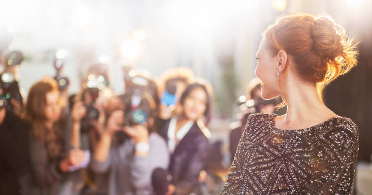 Talent with photographers on red carpet for entertainment social media at awards.