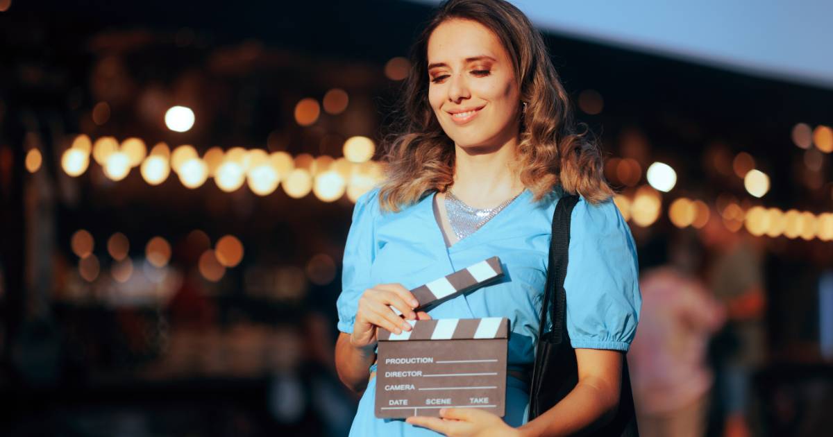Actress in blue dress with clapboard for entertainment marketing