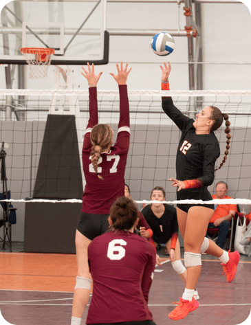 women playing collegiate volleyball indoor